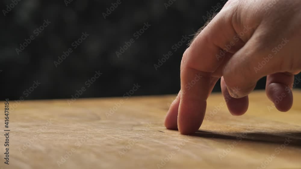 Men hand making standing person with fingers, a walking man. The fingers are walking like a figure on a wooden table on a black background. Men hand making standing person with fingers, a walking man. The fingers are walking like a figure on a wooden table on a black background.