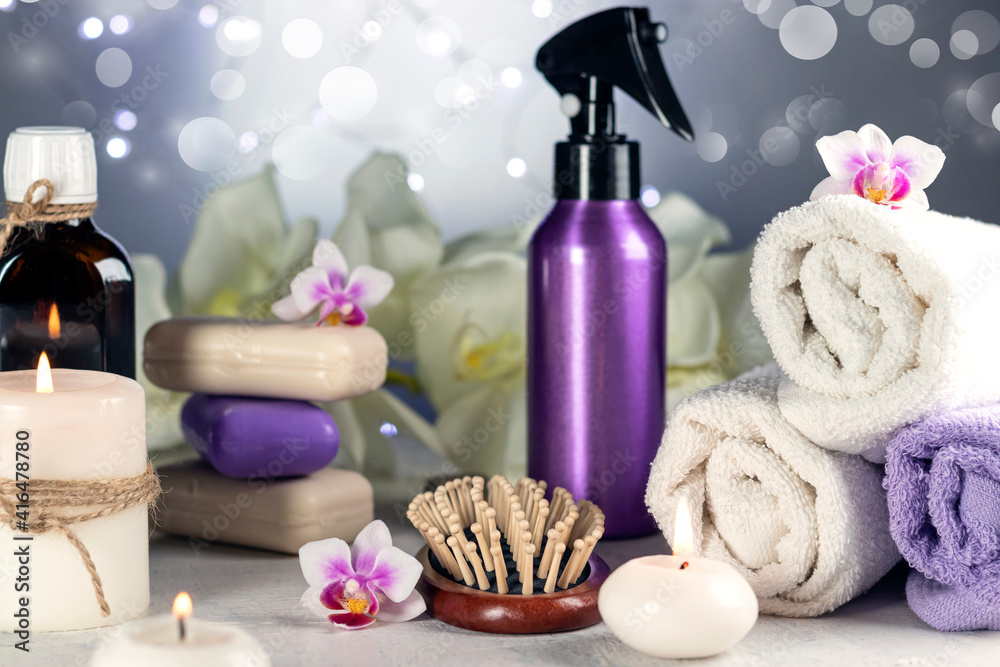 Spa resort therapy composition. Orchid flowers, burning candles, towel, massage oil, soap, washcloths, combs abstract lights Spa resort therapy composition. Orchid flowers, burning candles, towel, massage oil, soap, washcloths, combs abstract lights