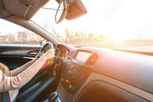 Travel trip car. Happy young woman inside vehicle driving in sunny day. Fun driver ride in winter vacation concept.