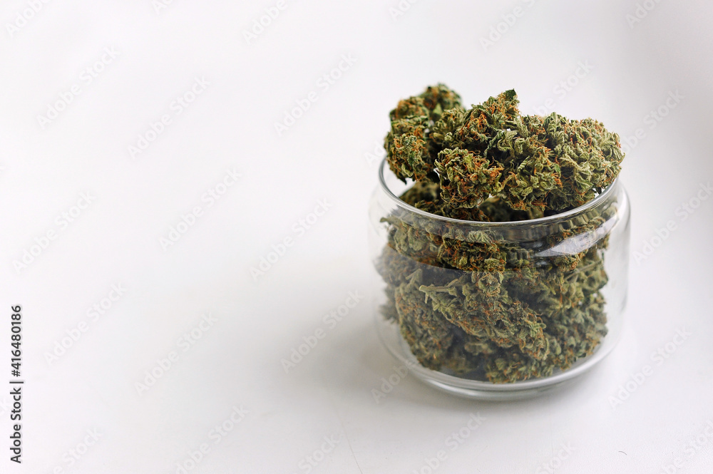 Marijuana buds storage. Medicinal cannabis flowering on white background, isolated. Hemp recreation, medical usage, legalization. Marijuana buds storage. Medicinal cannabis flowering on white background, isolated. Hemp recreation, medical usage, legalization.