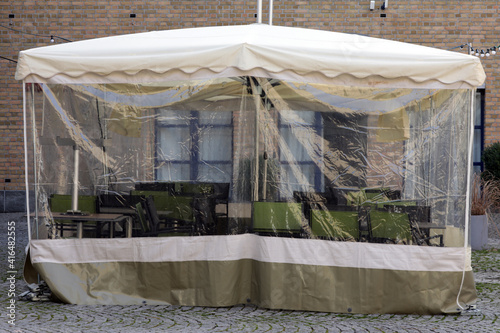 Fototapeta Naklejka Na Ścianę i Meble -  zelt schutz abdeckung für möbel einer terrasse im lockdown in der gastronomie