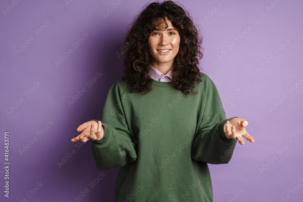 Happy puzzled curly girl smiling and gesturing with hands Happy puzzled curly girl smiling and gesturing with hands