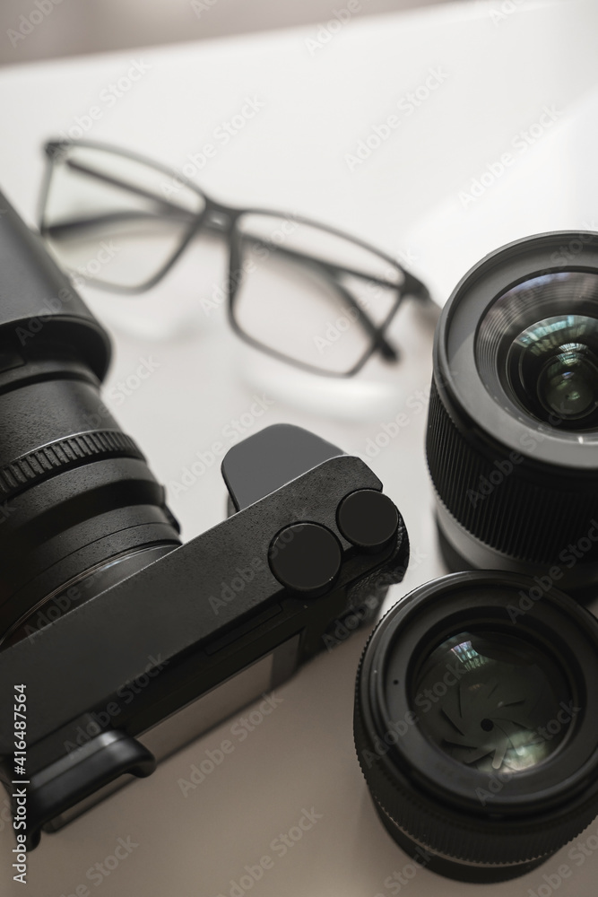Workplace with a modern equipment for photography. Mirrorles camera and prime lenses. Workplace with a modern equipment for photography. Mirrorles camera and prime lenses.