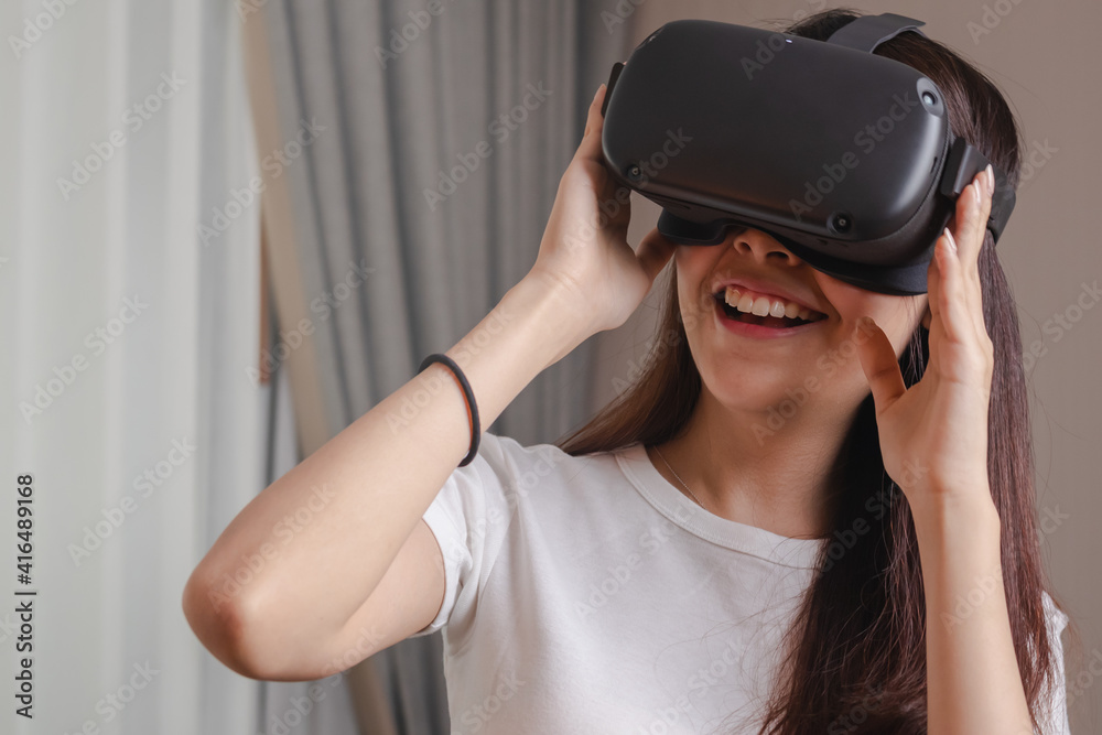 Pretty asian young woman touching, wearing VR headset or visual reality goggles, glasses or gadget. Girl play videogame of simulator future,futuristic while wearable. Technology of modern concept. Pretty asian young woman touching, wearing VR headset or visual reality goggles, glasses or gadget. Girl play videogame of simulator future,futuristic while wearable. Technology of modern concept.