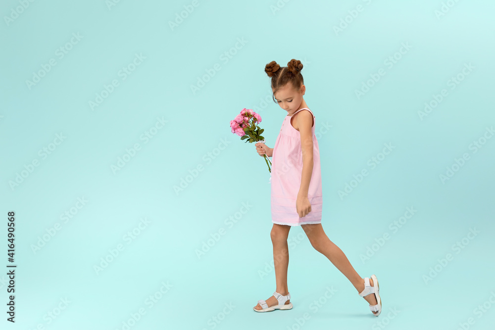 happy little girl holds bouquet of roses isolated on blue background. Mother's day. happy little girl holds bouquet of roses isolated on blue background. Mother's day.