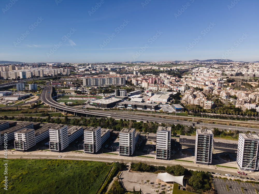 Lisbon, Portugal - 14 February 2021: Aerial view of a modern residential district with a busy highway road crossing Lisbon suburban district, Oriente, Portugal.