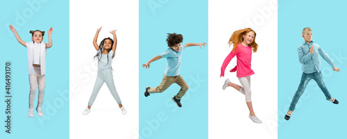 Group of elementary school kids or pupils jumping in colorful casual clothes on bicolored studio background. Creative collage. Back to school  education  childhood concept. Cheerful girls and boys.
