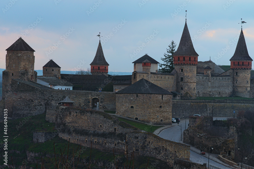 Detailed view of Kamianets-Podilskyi castle during sunset. Blue sky in the background. Famous touristic place and romantic travel destination in the city. Landscape during the winter season, no snow