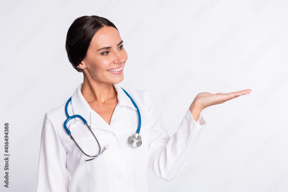 Photo of good mood pretty young lady medic dressed uniform holding arm looking empty space isolated white color background Photo of good mood pretty young lady medic dressed uniform holding arm looking empty space isolated white color background
