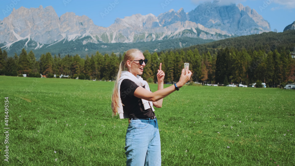 Pretty woman making video call from beautiful nature park in front of mountains. She sharing impressions from her trip. Pretty woman making video call from beautiful nature park in front of mountains. She sharing impressions from her trip.
