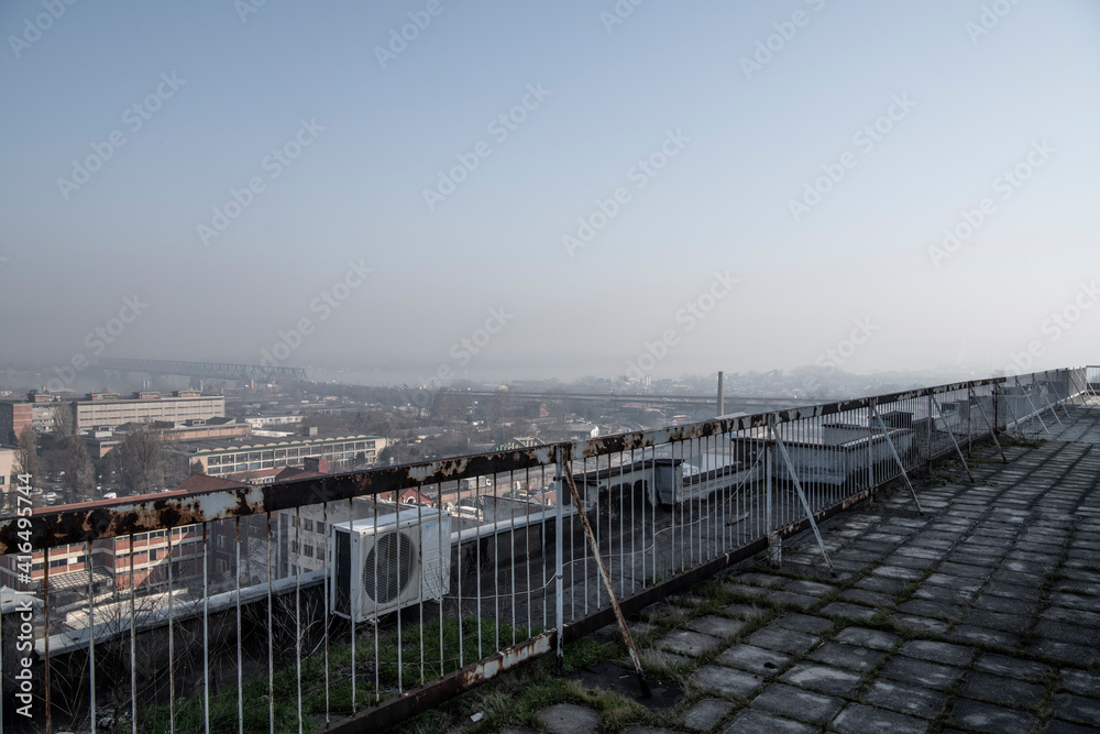 Smog lies over the skyline of Historical architecture of Belgrade city. Poor visibility, smog, caused by air pollution. Rooftop view. Emissions of plants and factories. Belgrade, Serbia 25.02.2021