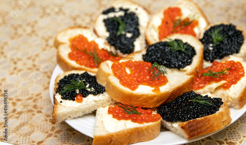 sandwiches with red and black caviar. White bread with butter and salmon caviar. On a light background. Selective focus.