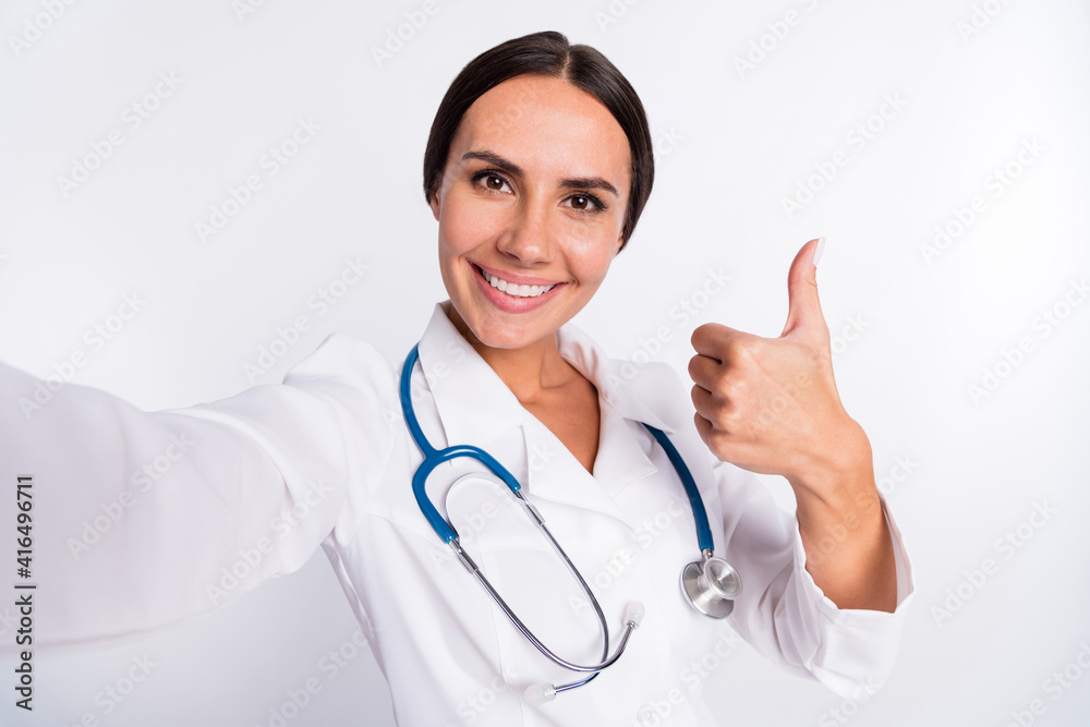 Fototapeta premium Photo of good mood positive young lady medic dressed uniform recording video showing thumb up isolated white color background