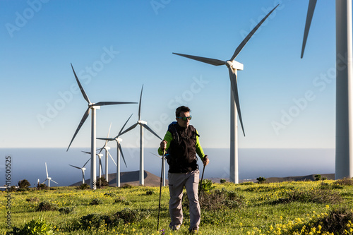 Male explorer in green field with windmills