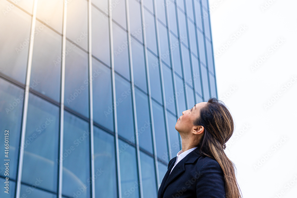 adult business woman looking at financial skyscraper, japanese female entrepreneur aiming to successful and big achievements, social affirmation and corporate outcome concept