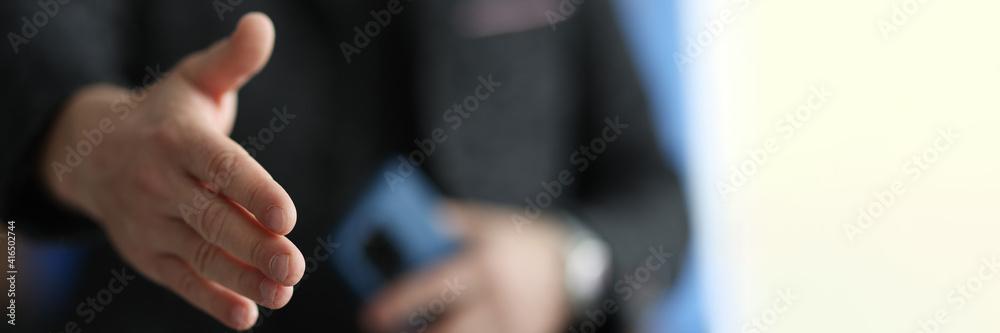Man stretches out his hand for handshake closeup. Conducting business deals concept. Man stretches out his hand for handshake closeup. Conducting business deals concept.