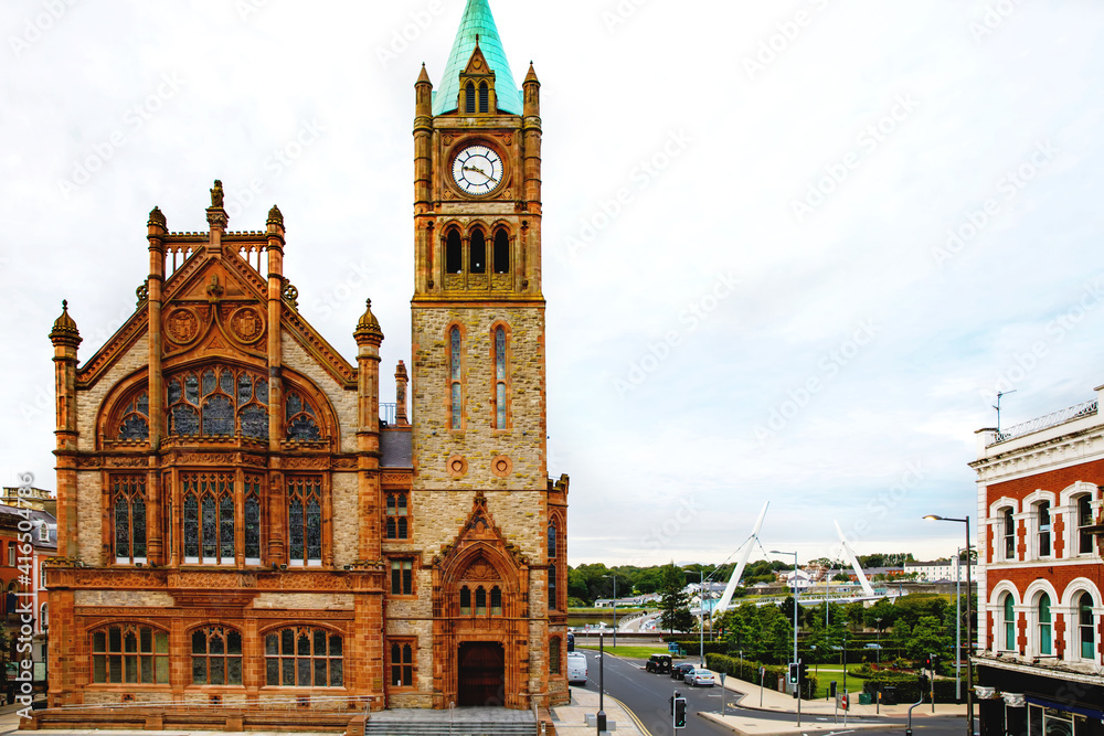 Fototapeta premium Derry, North Ireland. Aerial view of Derry Londonderry city center in Northern Ireland, UK. Sunny day with cloudy sky, city walls and historical buildings