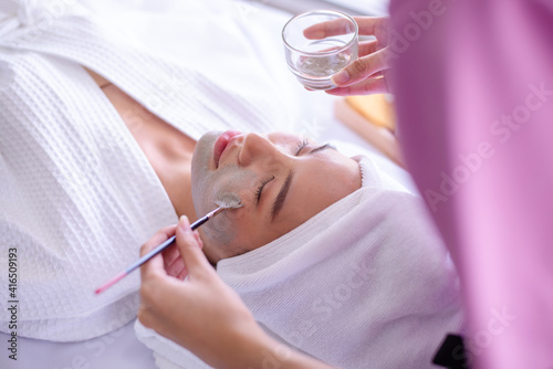 Therapist use clay facing mask for client in spa