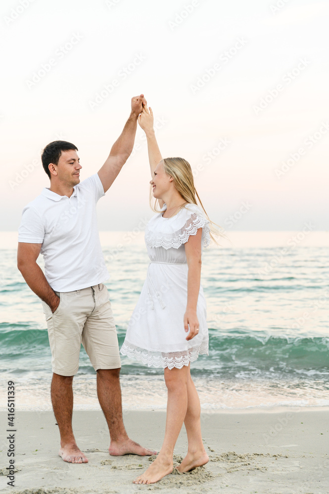 happy couple hugging on the seashore at sunset of the day. summer romance of lovers. walk near the sea. newlyweds on honeymoon. romantic time. happy young people. happy couple hugging on the seashore at sunset of the day. summer romance of lovers. walk near the sea. newlyweds on honeymoon. romantic time. happy young people.