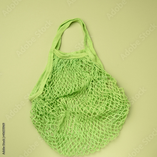 empty green reusable string bag woven from thread on a green background