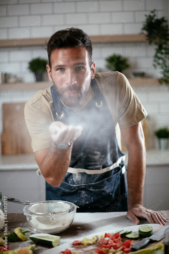 Handsome man preparing bread at home. Happy man having fun while baking a fresh pasta. Handsome man preparing bread at home. Happy man having fun while baking a fresh pasta.