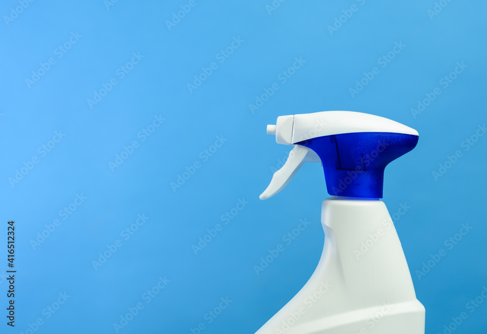 white plastic bottle with spray and foam nozzle with detergent on blue background white plastic bottle with spray and foam nozzle with detergent on blue background