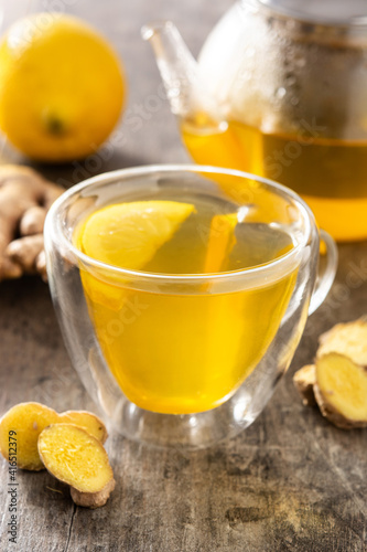 Ginger tea with lemon and honey in crystal glass on wooden table