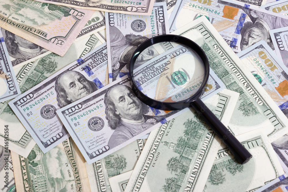 Magnifying glass on the background of bundle dollars - texture, background Magnifying glass on the background of bundle dollars - texture, background