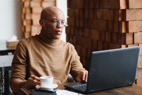 African american business man with laptop in a cafe