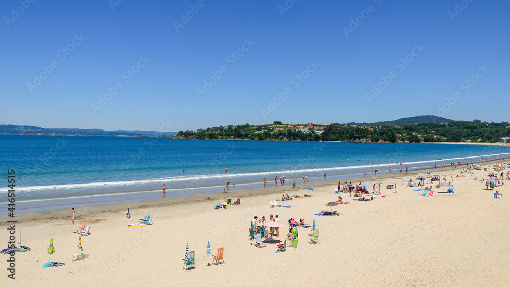 Panoramic view of the sandy beach of Miño in the Galicia region of Spain, with beach goers enjoying the summer weather.