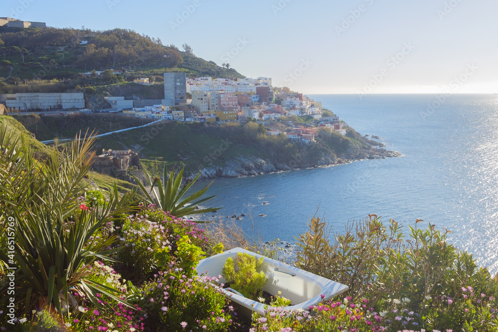 Ciudad costera española con naturaleza y una bañera en primer plano