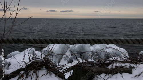 Ice covered lakeshore relieving calm winter waters under a clear sky. photo