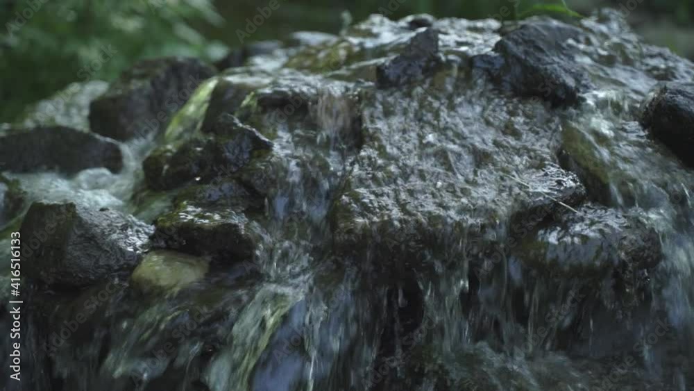 Close up of rock waterfall Flowing water. Tall swinging grass. Summer evening. Slow motion . Close up of rock waterfall Flowing water. Tall swinging grass. Summer evening. Slow motion .