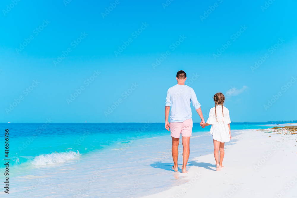 Little girl and happy dad having fun during beach vacation Little girl and happy dad having fun during beach vacation