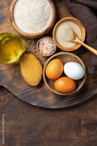  Ingredients for baking on a culinary background. Eggs, flour, dry yeast, sugar, salt on the kitchen table. The concept of preparation for yeast baking. Top view