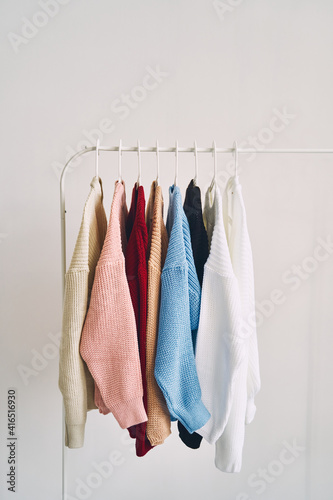 multicolored women's woolen sweaters on hangers. Sale in a fashion store
