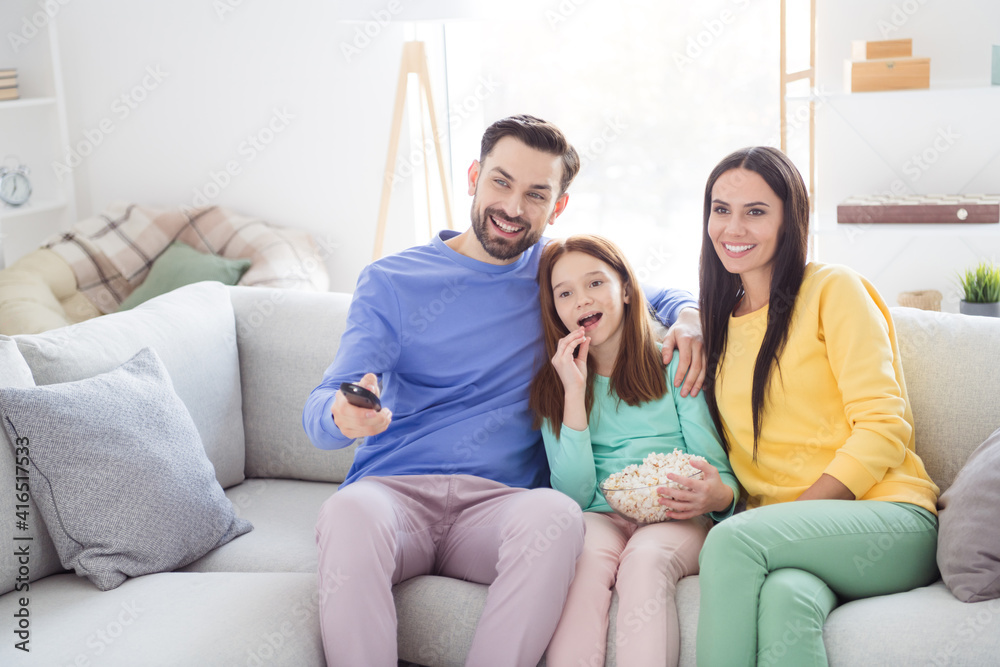 Photo of young cheerful family happy positive smile sit sofa home watch television eat popcorn switch channel remote controller