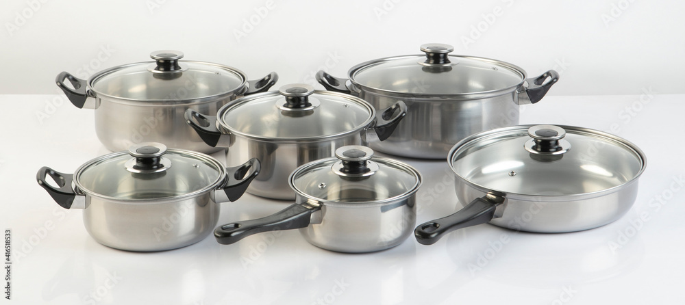 Set of stainless pots with lids isolated on white Set of stainless pots with lids isolated on white