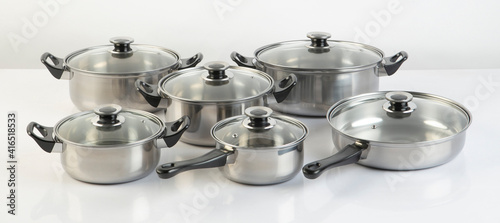 Set of stainless pots with lids isolated on white