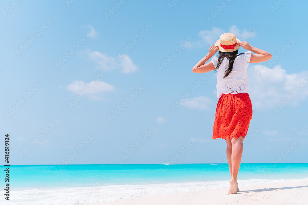 Young beautiful woman having fun on tropical seashore. Happy girl background the blue sky and turquoise water in the sea Young beautiful woman having fun on tropical seashore. Happy girl background the blue sky and turquoise water in the sea