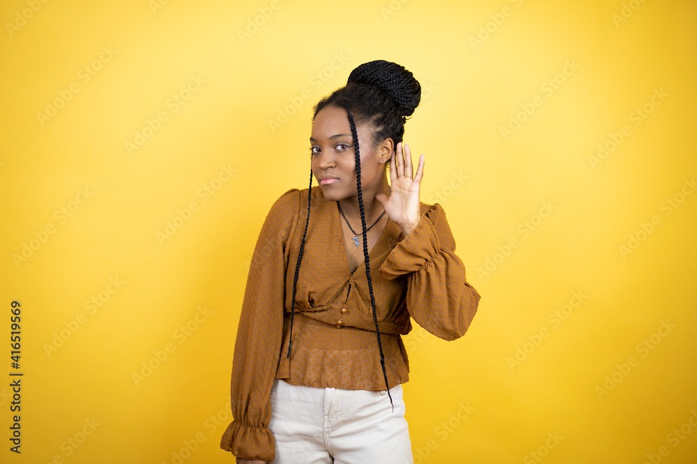 African american woman wearing casual clothes surprised with hand over ear listening an hearing to rumor or gossip African american woman wearing casual clothes surprised with hand over ear listening an hearing to rumor or gossip