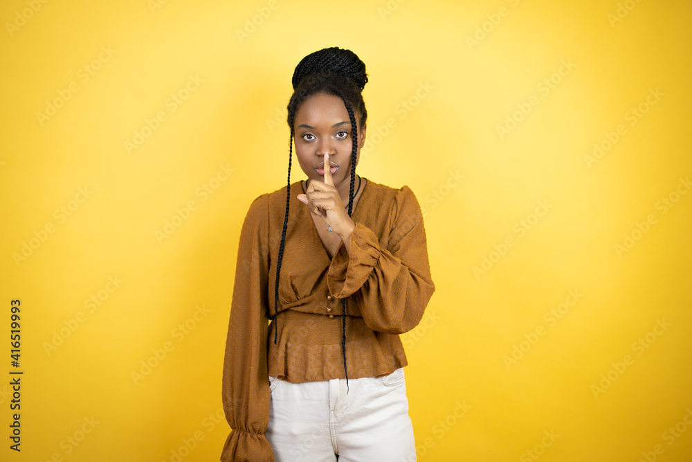 African american woman wearing casual clothes asking to be quiet with finger on lips. Silence and secret concept.