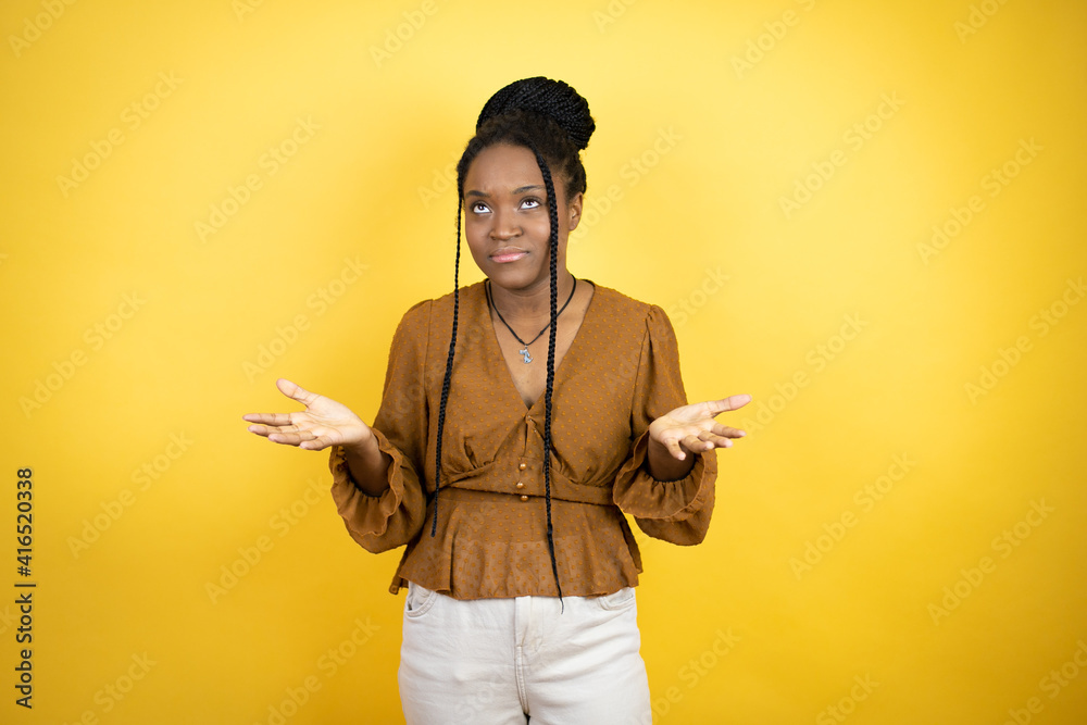 African american woman wearing casual clothes clueless and confused expression with arms and hands raised