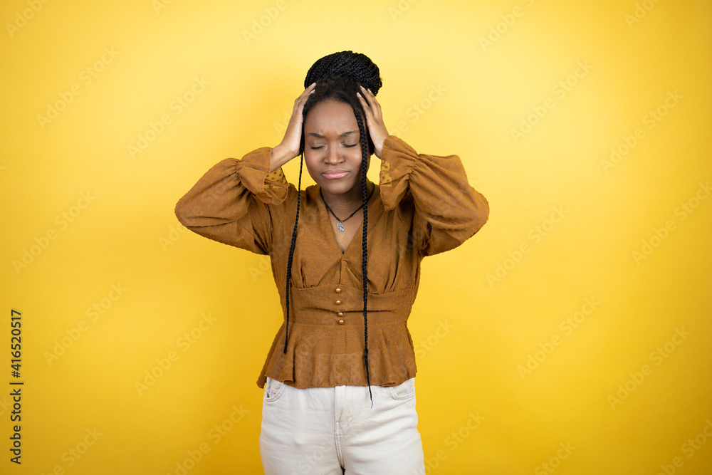 African american woman wearing casual clothes suffering from headache desperate and stressed because pain and migraine with her hands on head African american woman wearing casual clothes suffering from headache desperate and stressed because pain and migraine with her hands on head