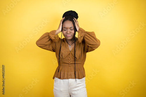 African american woman wearing casual clothes suffering from headache desperate and stressed because pain and migraine with her hands on head © Irene