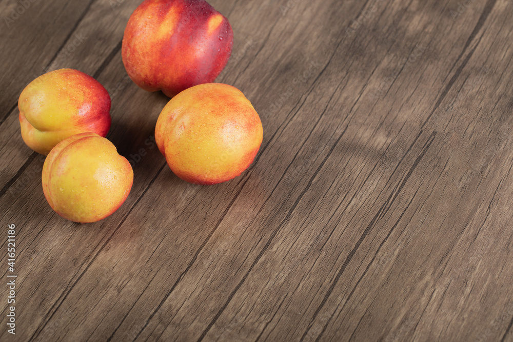 Red yellow peach isolated on a wooden table Red yellow peach isolated on a wooden table