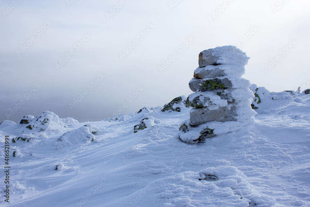 snow-covered stone tower on the mountain in cold winter