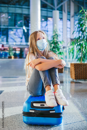 Little kid in medical mask in airport waiting for boarding