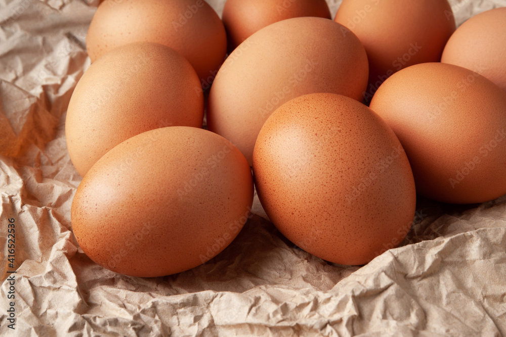 Group of brown eggs. Close-up of raw brown chicken eggs on crumpled wrapping paper. High calorie protein food concept. Group of brown eggs. Close-up of raw brown chicken eggs on crumpled wrapping paper. High calorie protein food concept.