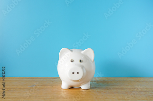 White Piggy bank on blue background with copy space 